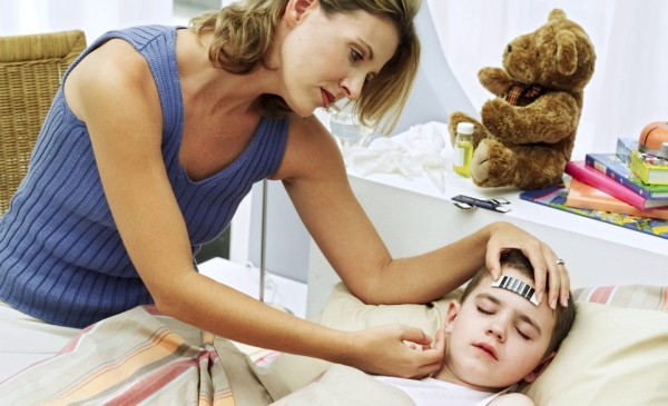 Young Woman Taking Sons Temperature --- Image by © Royalty-Free/Corbis